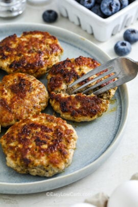 breakfast sausage patties on a plate with a fork