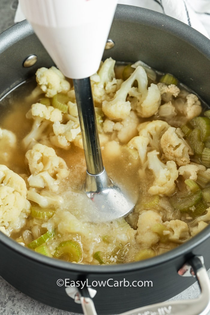 cauliflower and broth being blended in a pot for creamy cauliflower soup