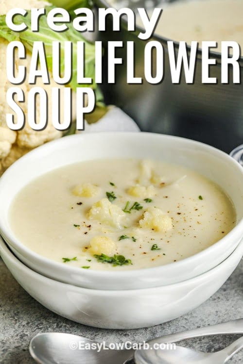 creamy cauliflower soup in a white bowl with writing