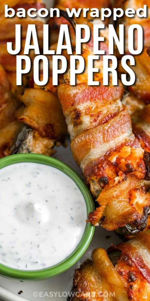 close up of bacon wrapped jalapenos with a bowl of dip and writing