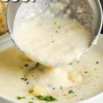creamy cauliflower soup in a bowl with a ladle and writing