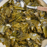 sauteed collard greens in a frying pan with a spoon