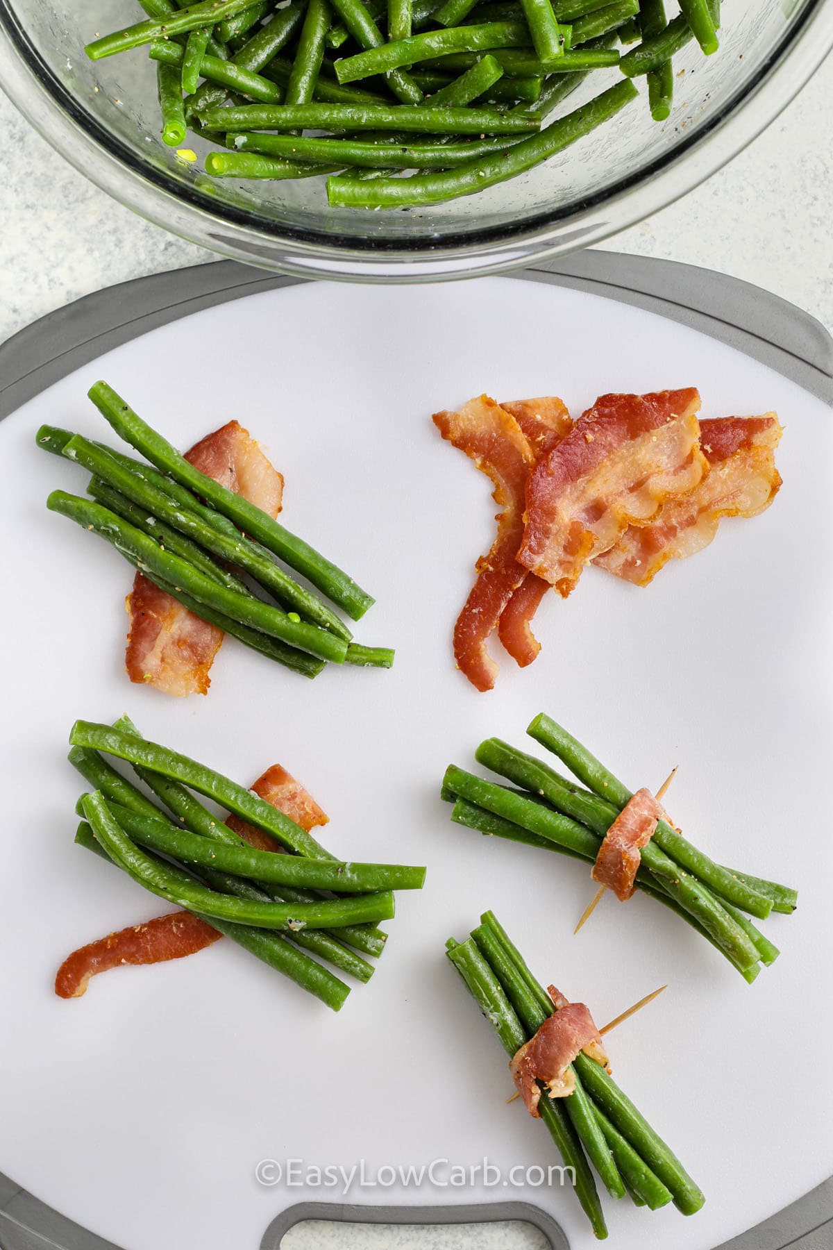 wrapping bacon around green beans to make Bacon Wrapped Green Beans