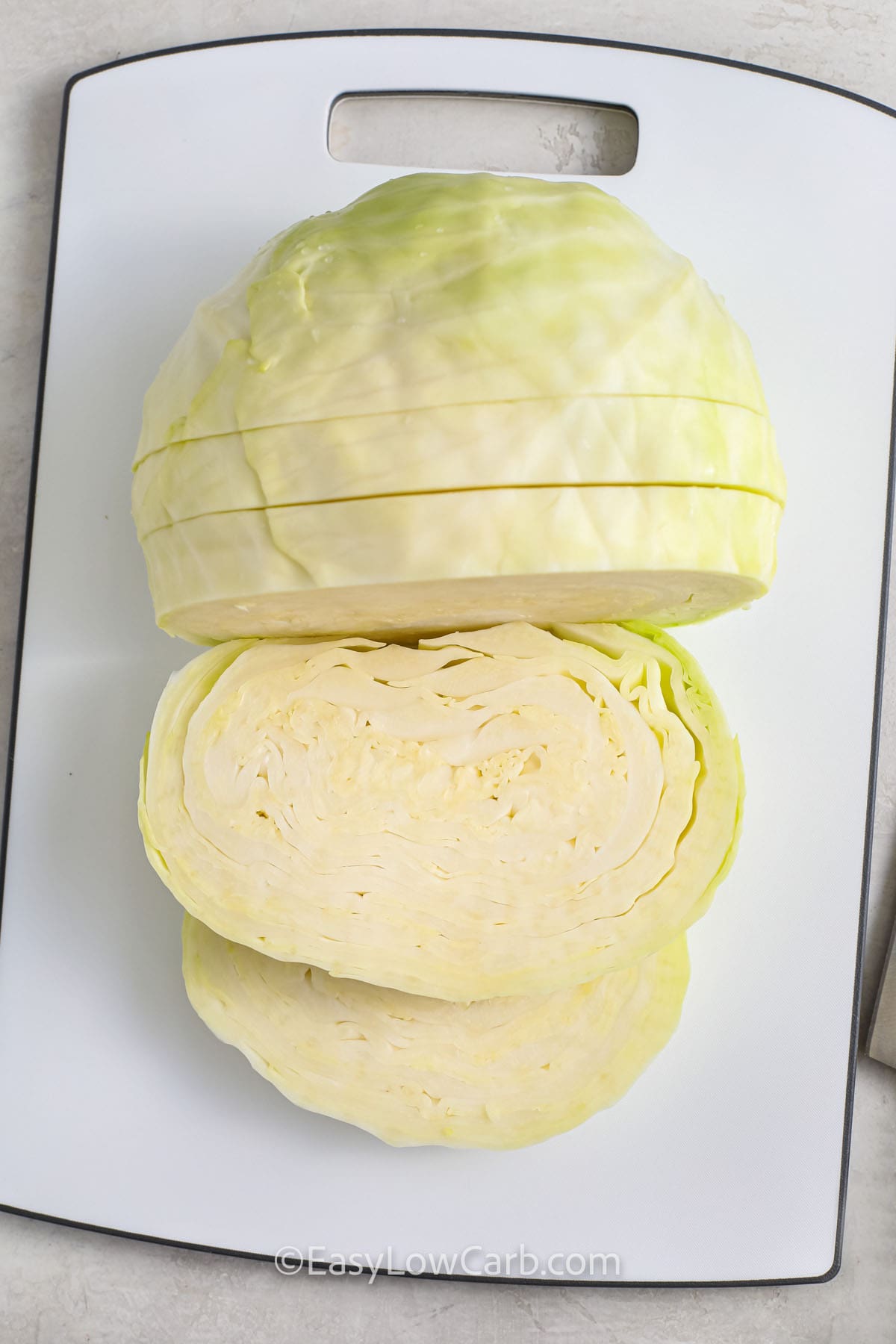 A head of cabbage being cut into slices