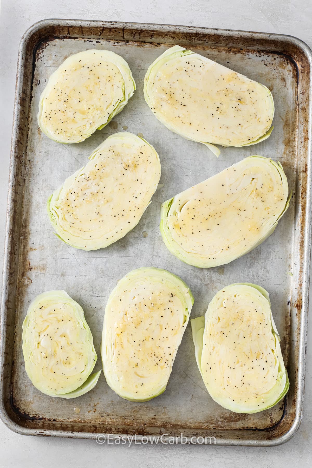 cabbage slices seasoned on a baking tray
