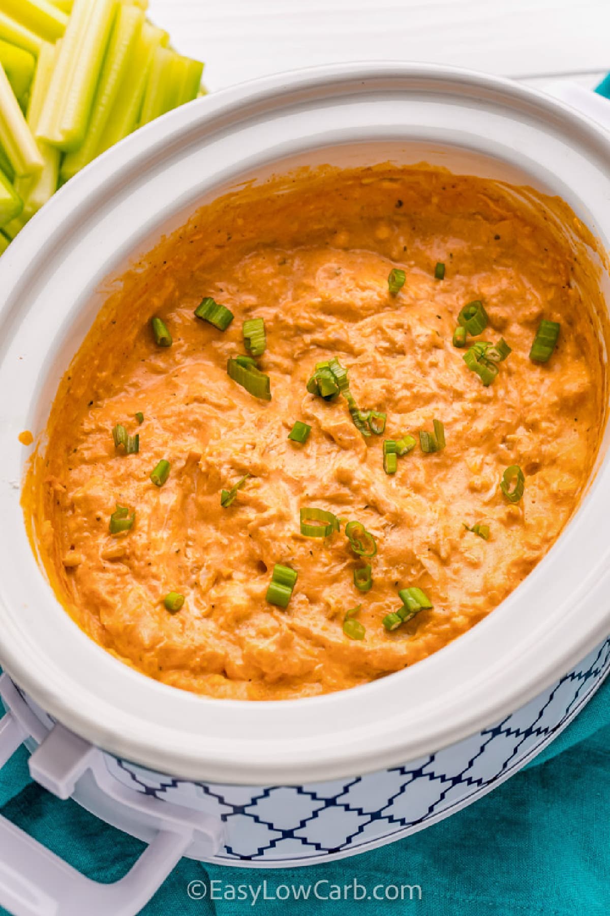 crock pot buffalo chicken dip recipe, served in a crockpot, garnished with green onion