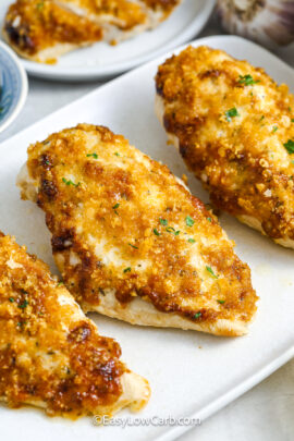 Three baked chicken breasts on a plate