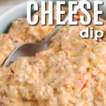 plated Sausage Cheese Dip with a spoon and writing