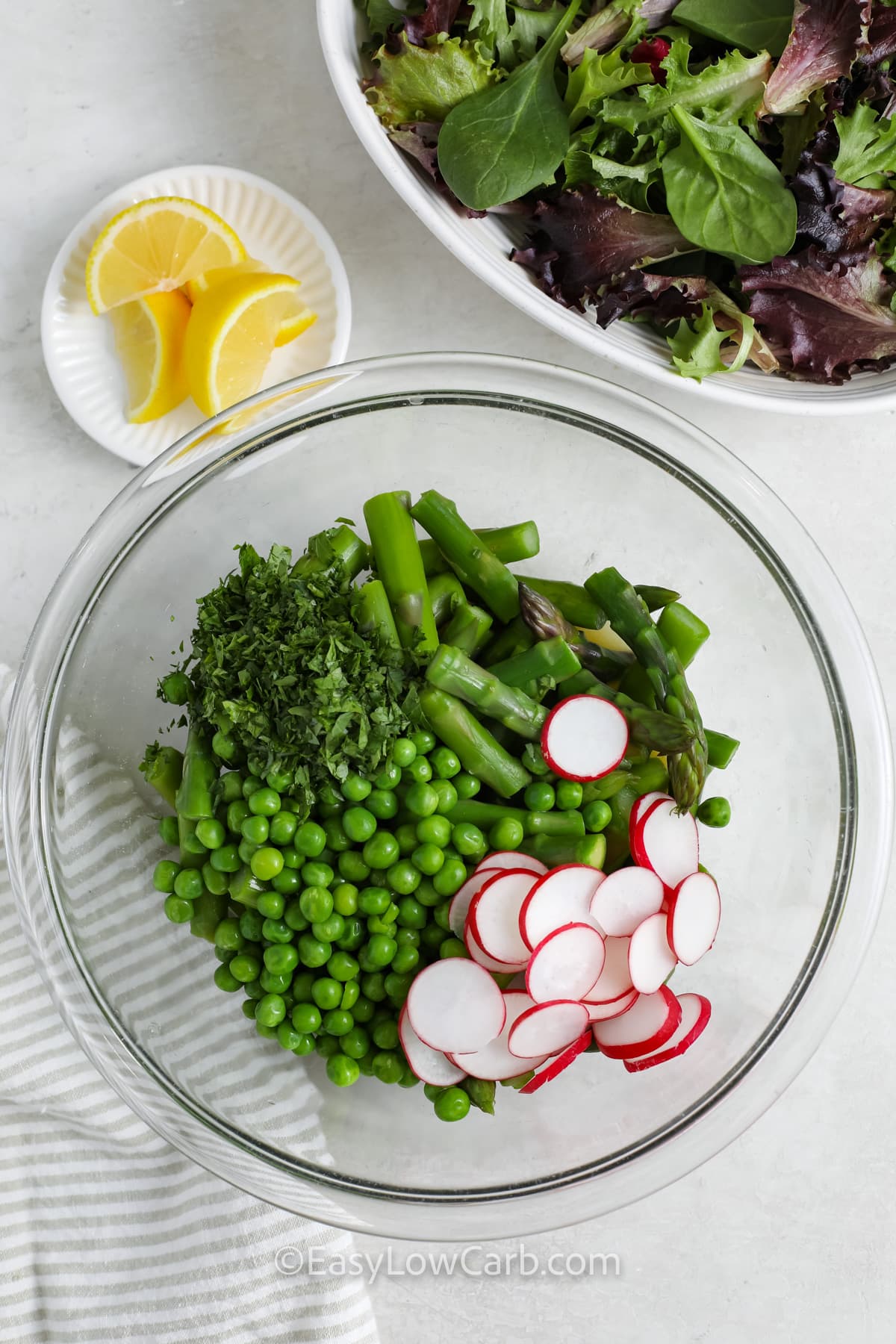 Ingredients to make asparagus salad being combined in a bowl