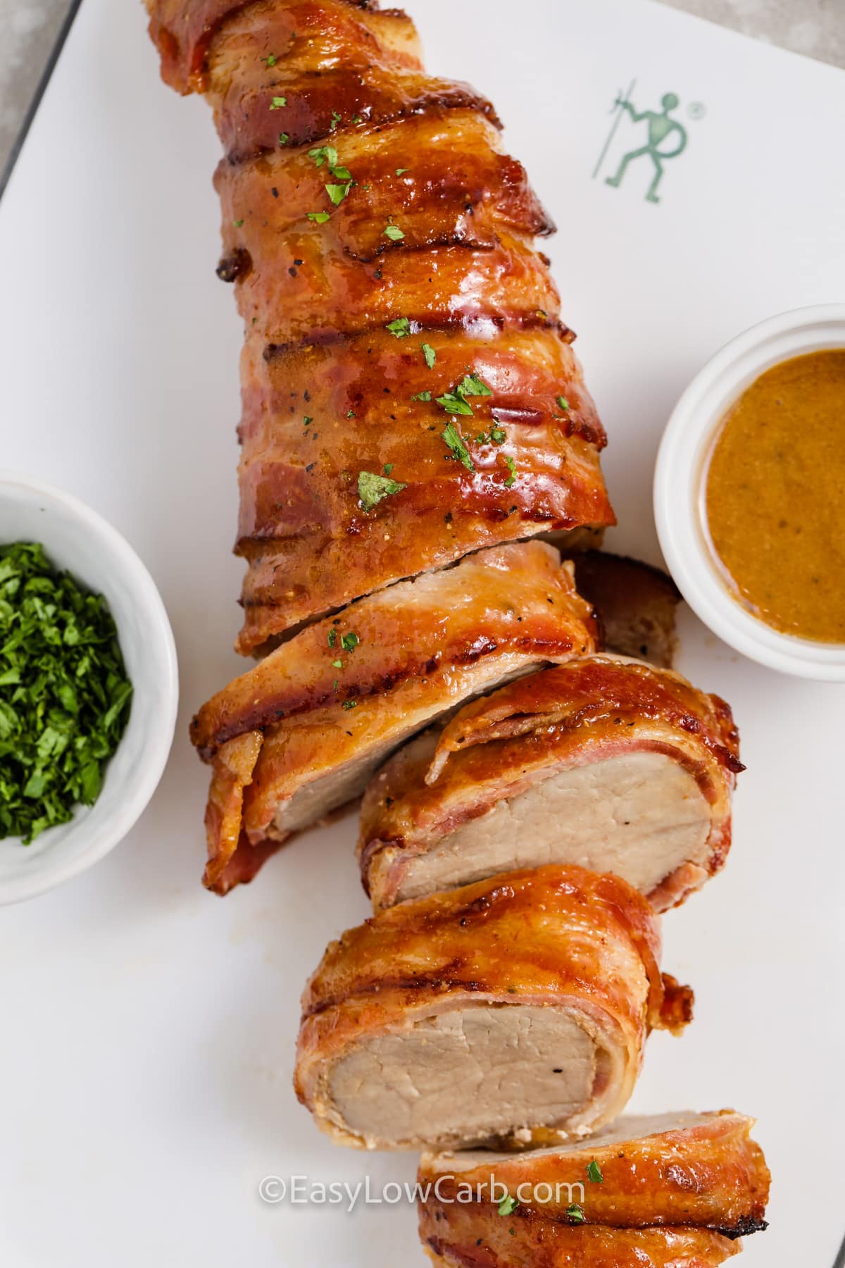 sliced bacon wrapped pork tenderloin topped with parsley