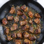 garlic steak bites sizzling in a pan