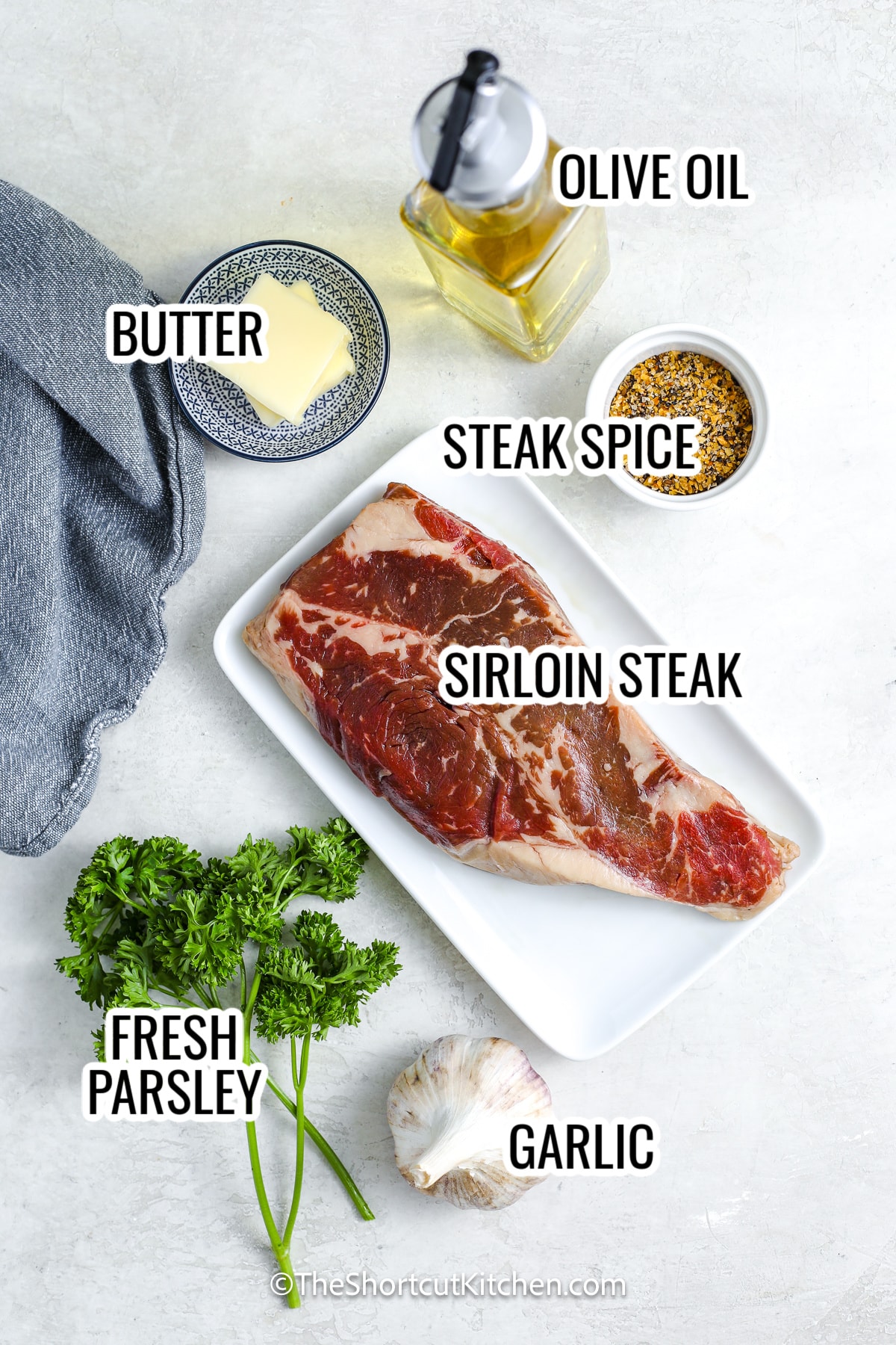 ingredients assembled to make garlic steak bites including steak, butter, garlic, olive oil, and steak spice