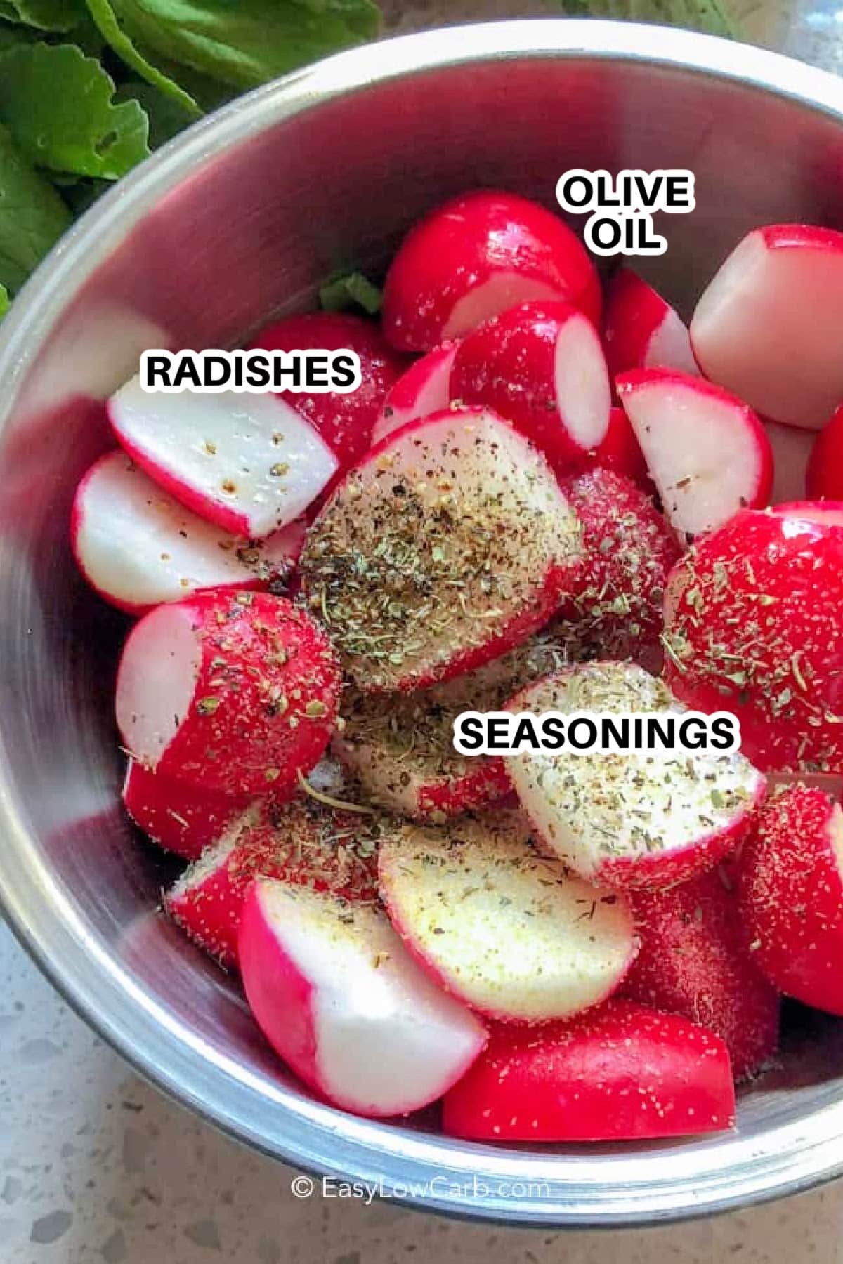 raw radishes, olive oil, and seasonings in a silver bowl