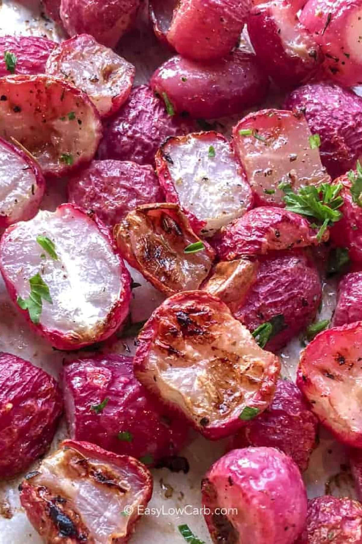 roasted radishes recipe on a parchment lined sheet garnished with parsley
