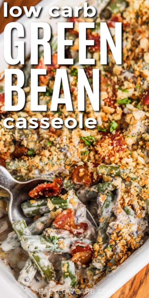 Keto Green Bean Casserole, with a spoon in the corner of a white casserole dish, with a title
