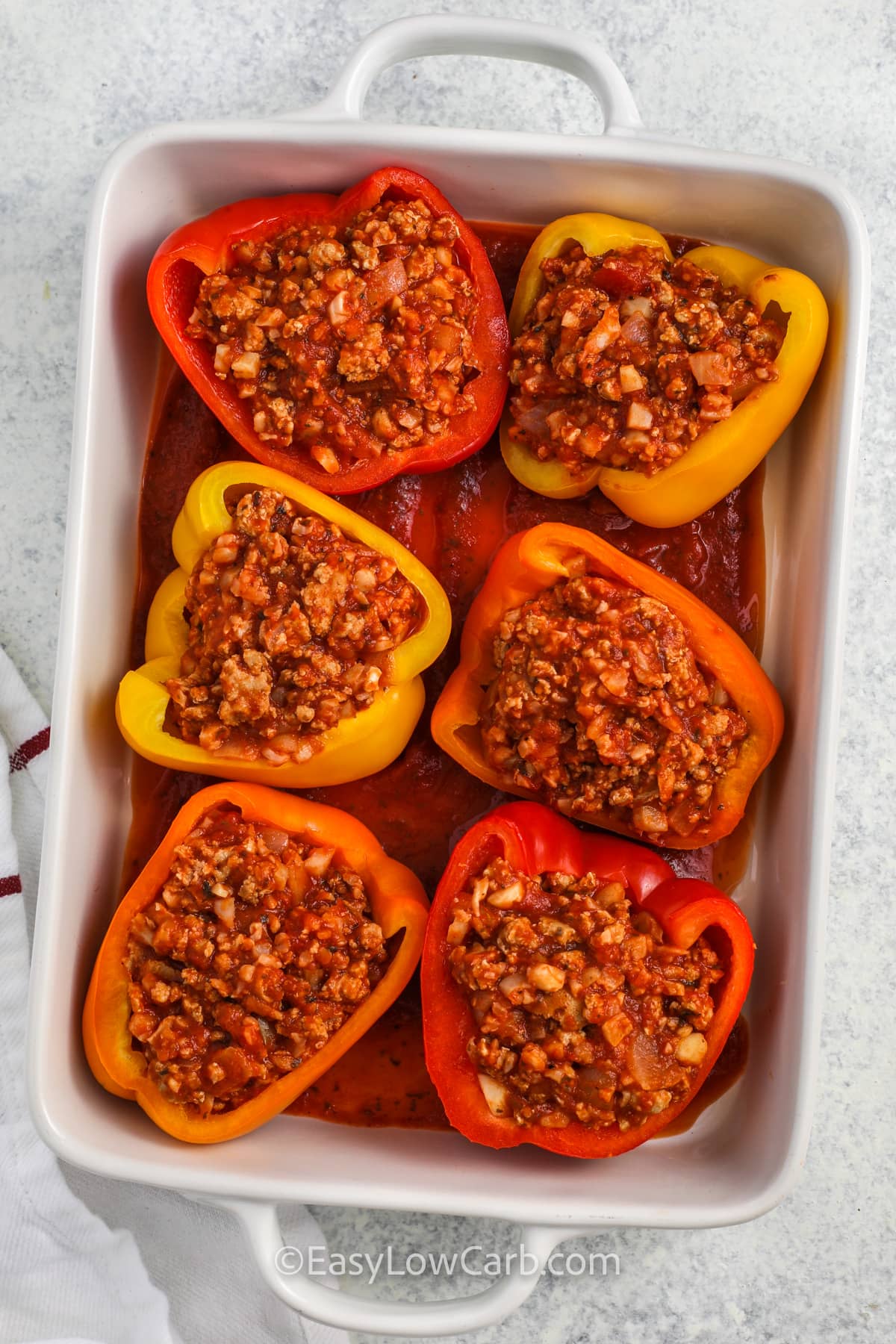 adding turkey mixture to peppers to make Ground Turkey Stuffed Peppers