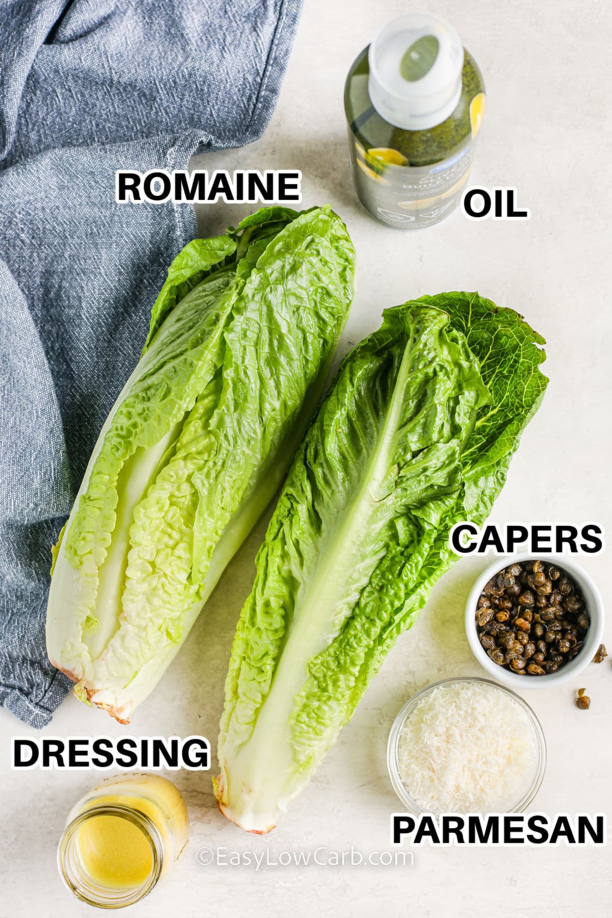 ingredients assembled to make grilled romaine salad including romaine, dressing, parmesan, capers, and oil