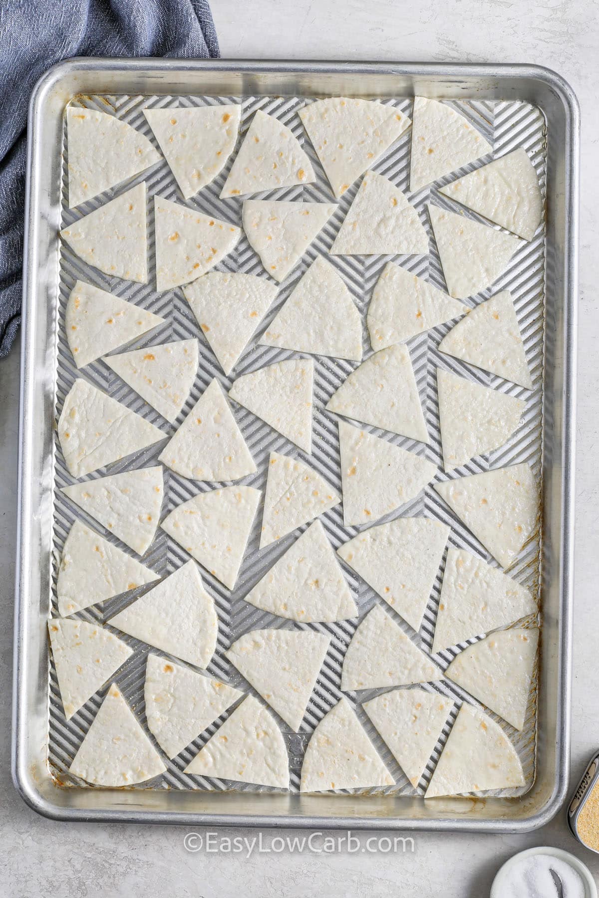 tortilla triangles on a sheet pan to make Low Carb Tortilla Chips