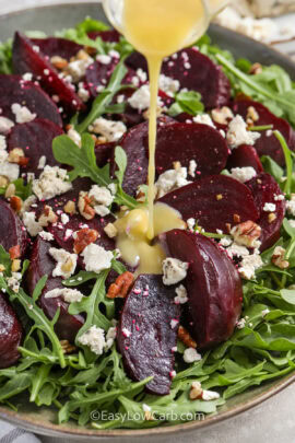 pouring dressing over Roasted Beet Salad