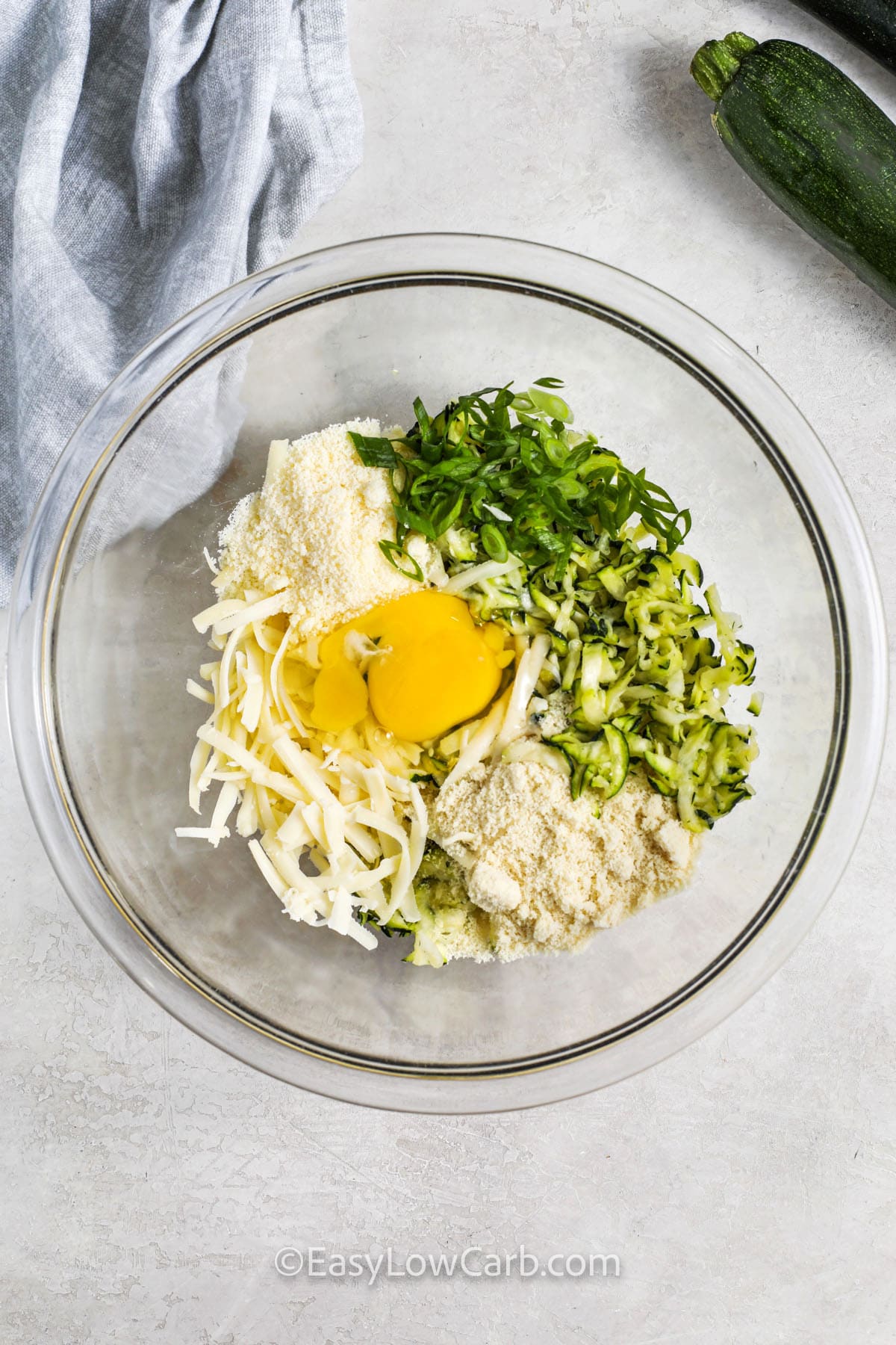 ingredients to make zucchini fritters in a bowl