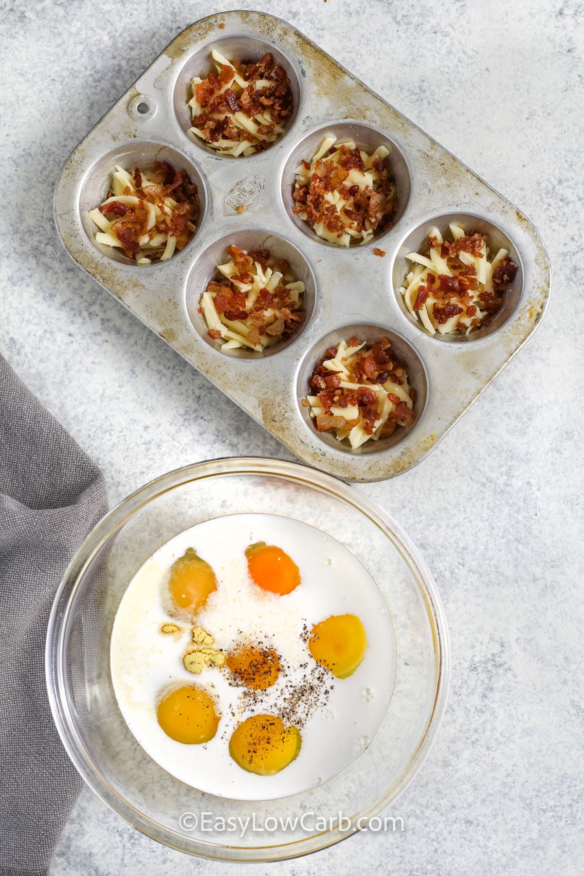 adding cheese and bacon to muffin tin to make Bacon and Gruyere Egg Bites