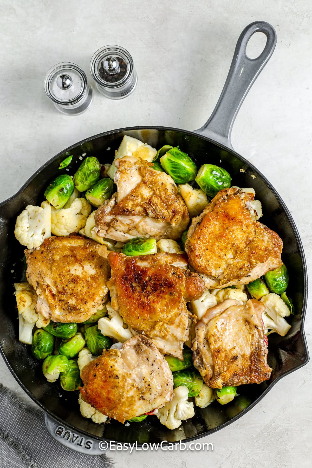 braised chicken thighs with cauliflower and brussels sprouts in a pan