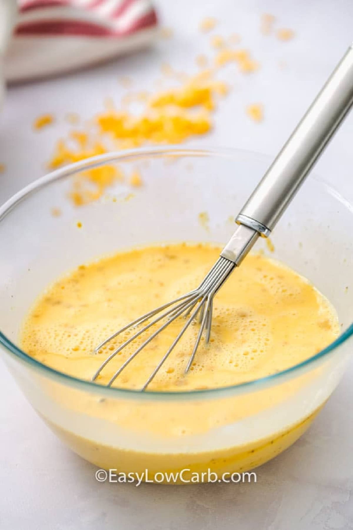 whisked egg mixture in a bowl to make Crustless Ham and Cheese Quiche