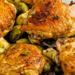 braised chicken thighs in a skillet with writing