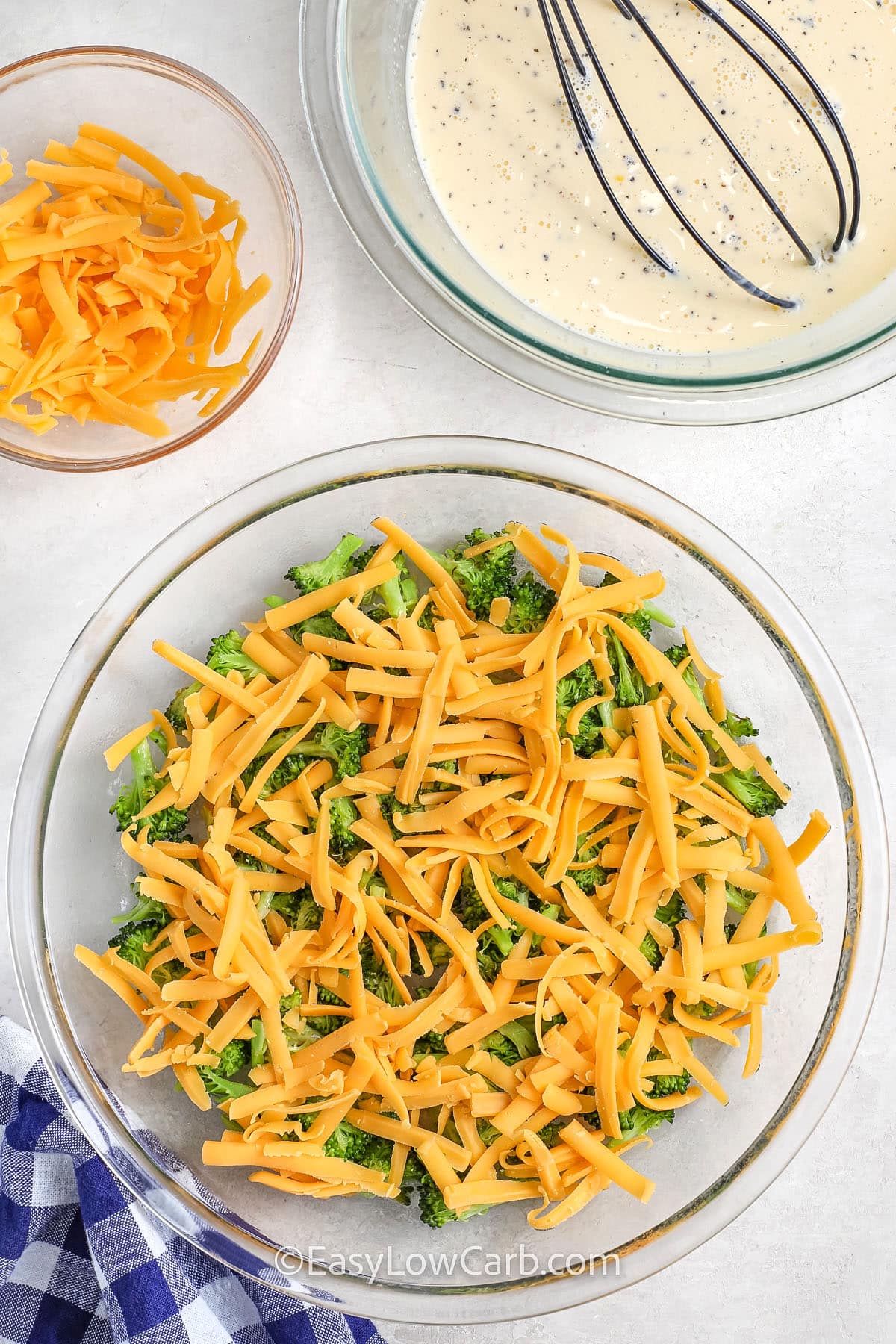 broccoli and cheese in a pie plate with an egg mixture in a bowl