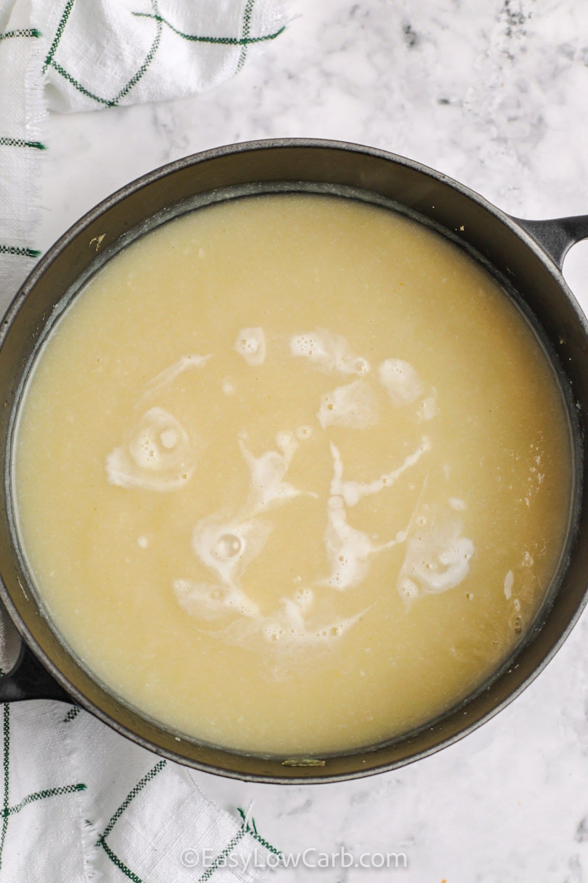 adding cream to pot to make Curried Cauliflower Soup.