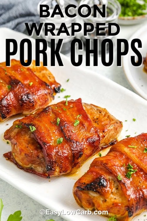 Three bacon wrapped pork chops on a serving dish with a title