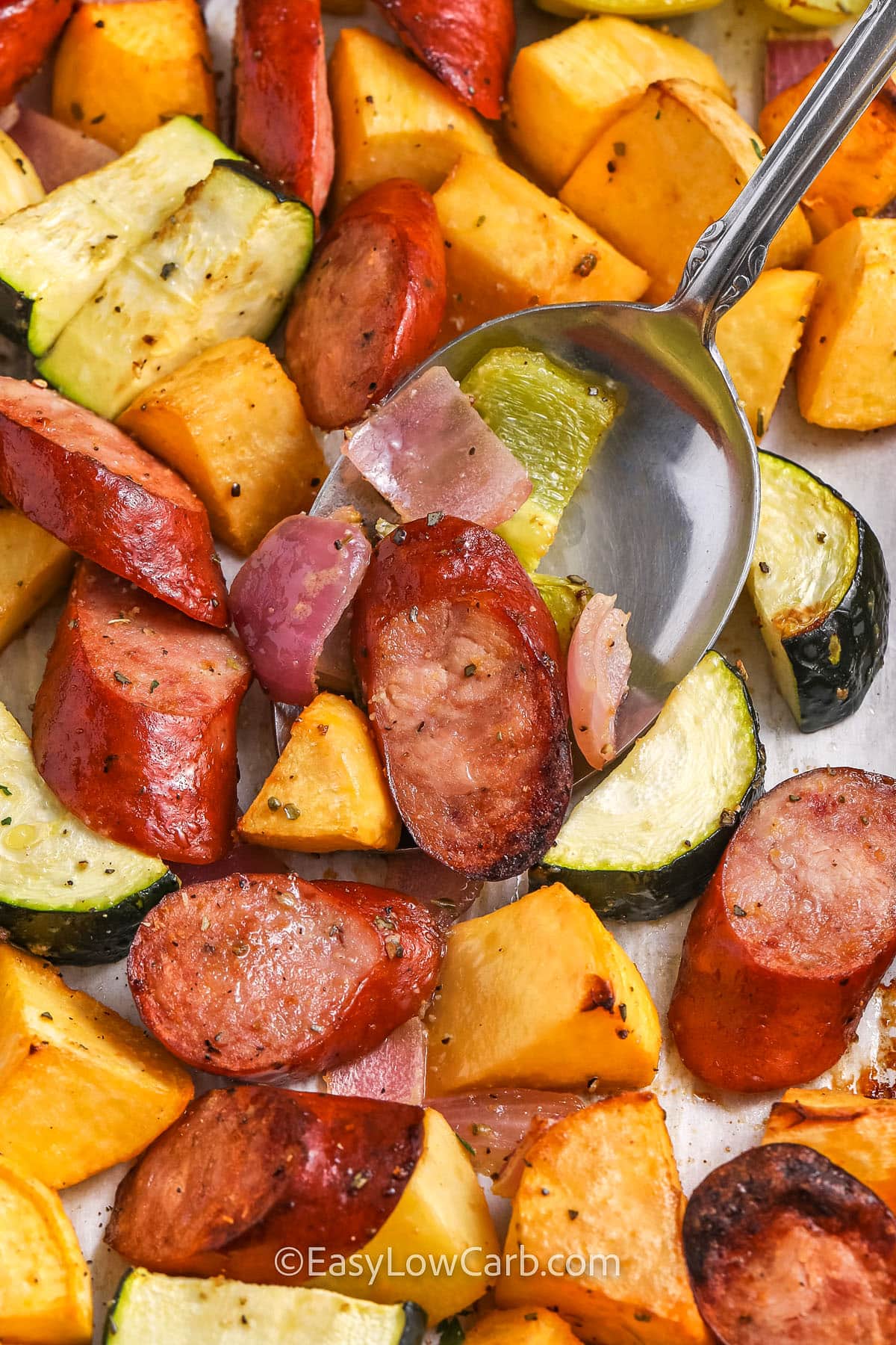 close up of Sheet Pan Sausage and Vegetables on a spoon