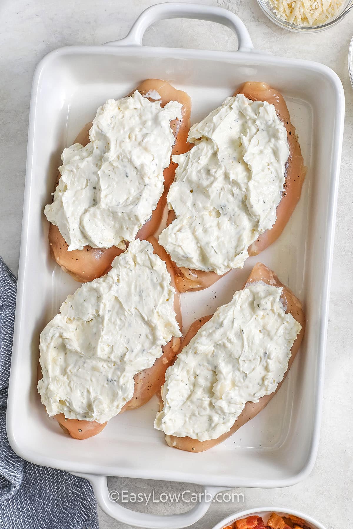 adding sauce to chicken to make Baked Ranch Chicken