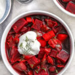 a bowl of beet soup with a dollop of sour cream on top