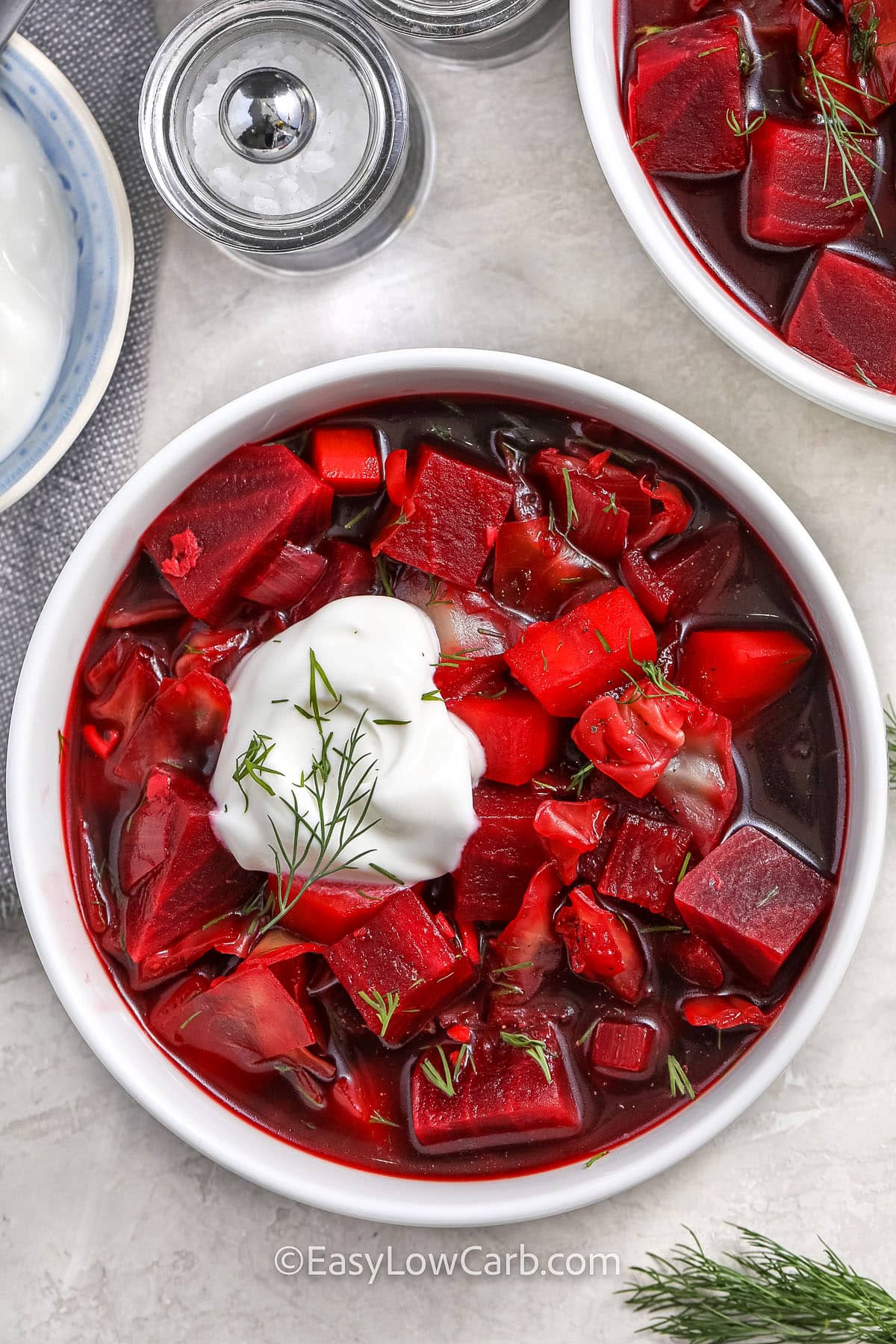 a bowl of beet soup with a dollop of sour cream on top