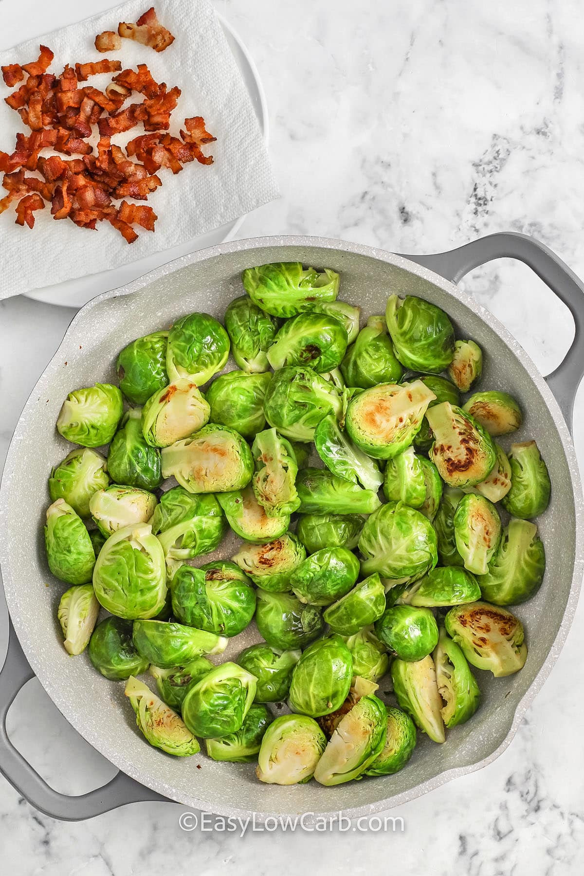 frying brussel sprouts with a plate of cooked bacon to make Brussel Sprout Casserole