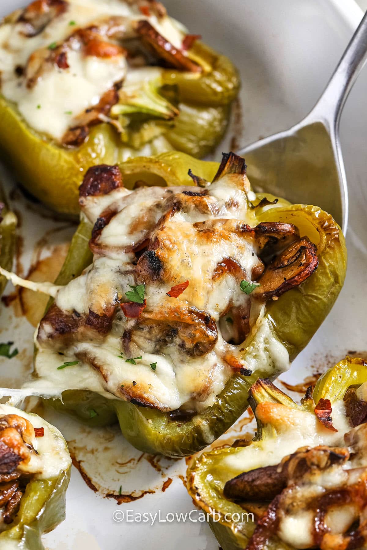 serving cheesesteak stuffed peppers from a baking dish