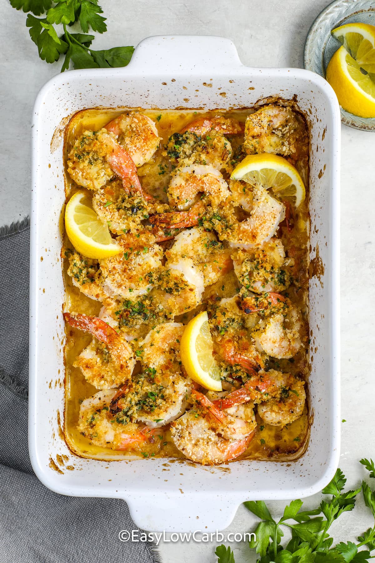 baked shrimp scampi with lemon slices in a casserole dish