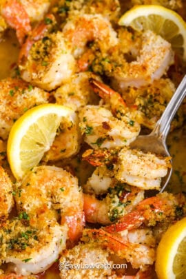 Baked shrimp scampi with lemon slices being served with a spoon