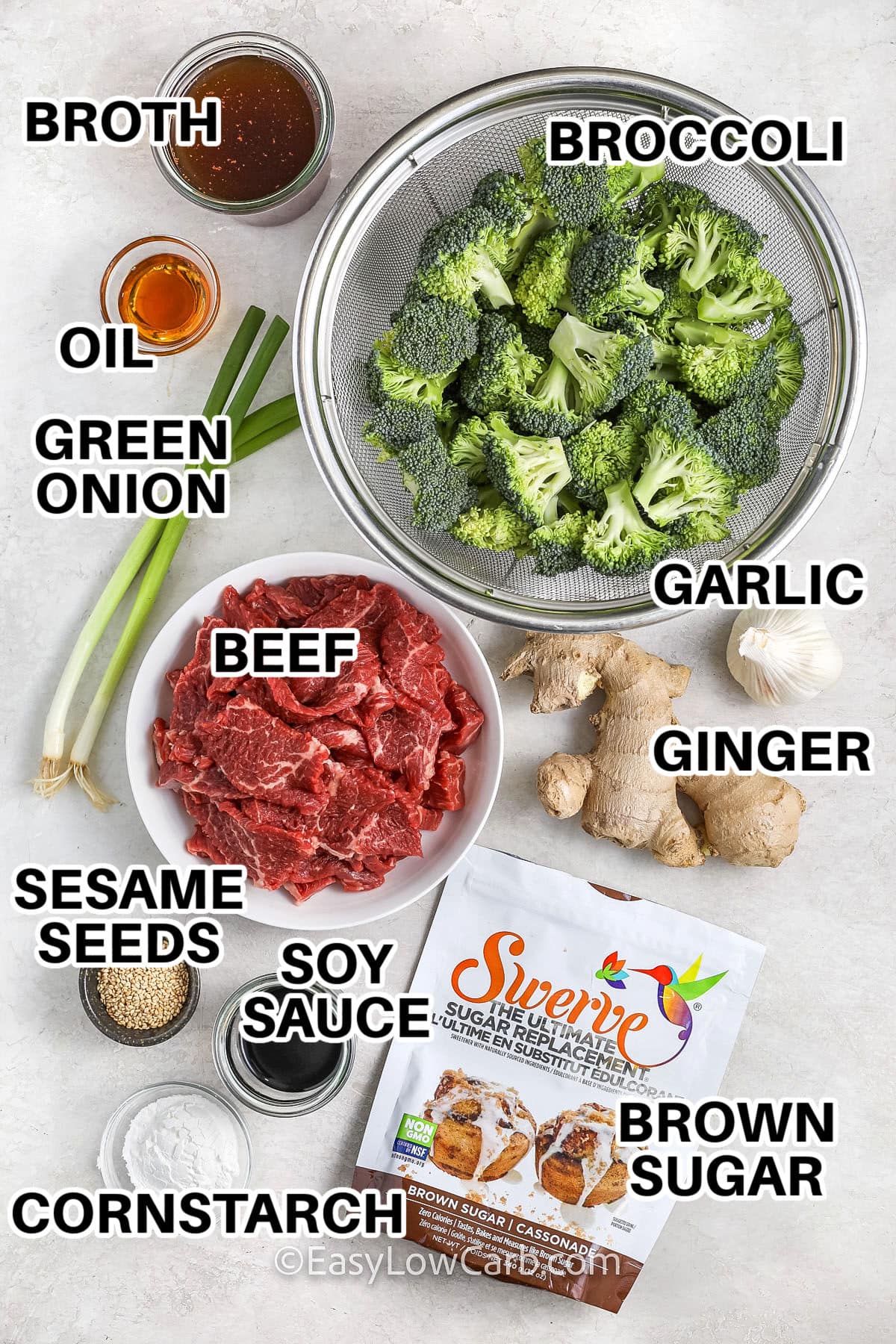 Ingredients for slow cooker beef and broccoli with labels for broth, oil, broccoli, beef, green onion, garlic, ginger, sesame seeds, soy sauce, brown sugar, and cornstarch.