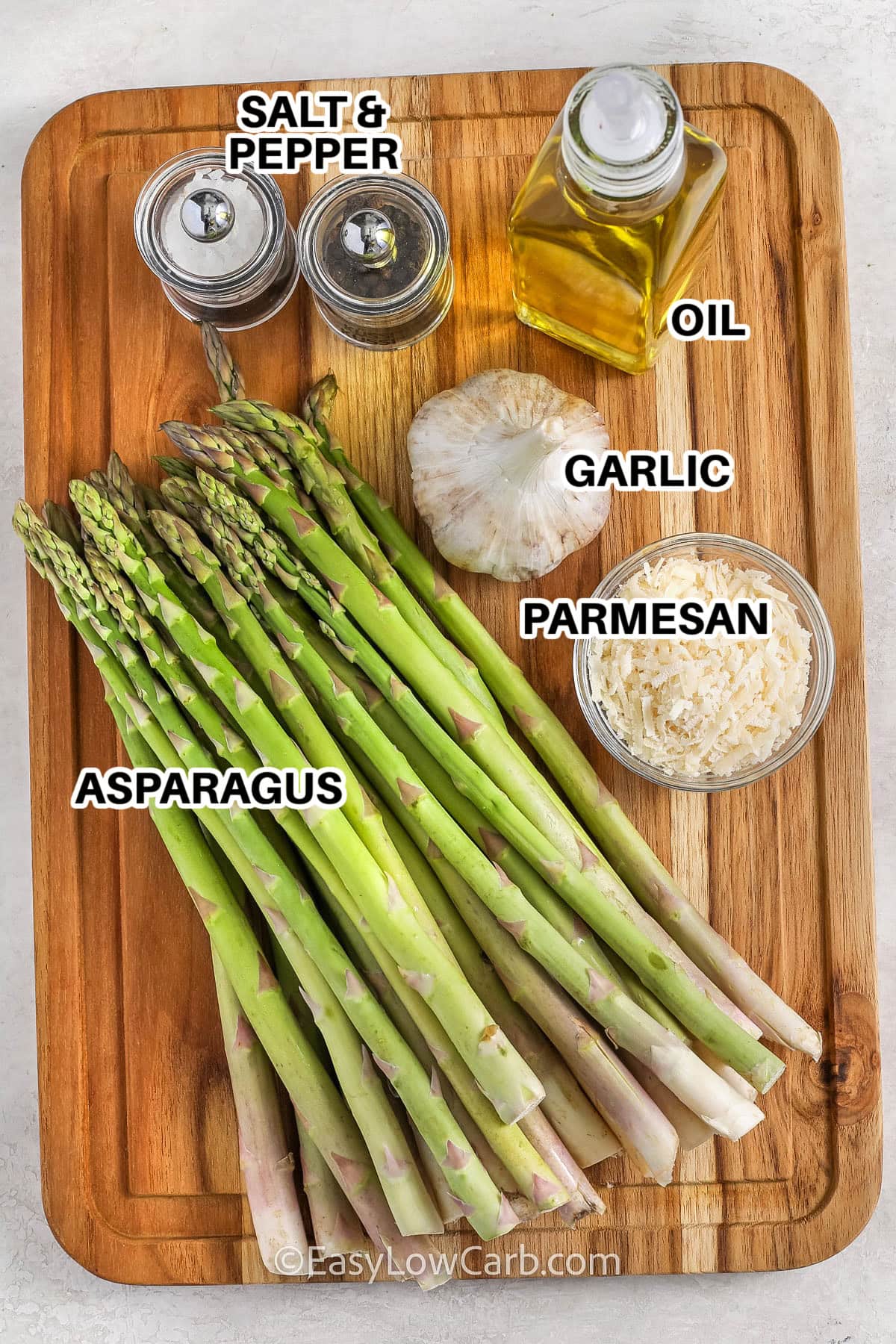 ingredients to make parmesan baked asparagus labeled: salt and pepper, oil, garlic, parmesan, and asparagus