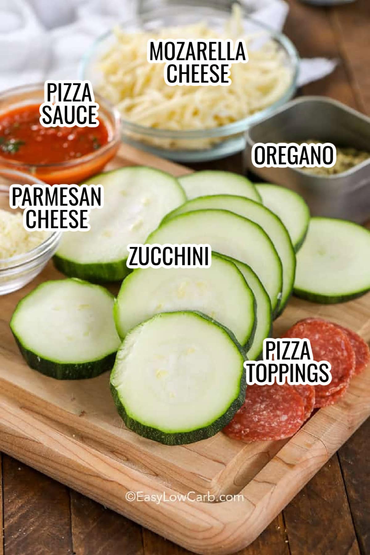 ingredients assembled to make zucchini pizza bites, including zucchini, mozarella cheese, parmesan cheese, pizza sauce, oregano