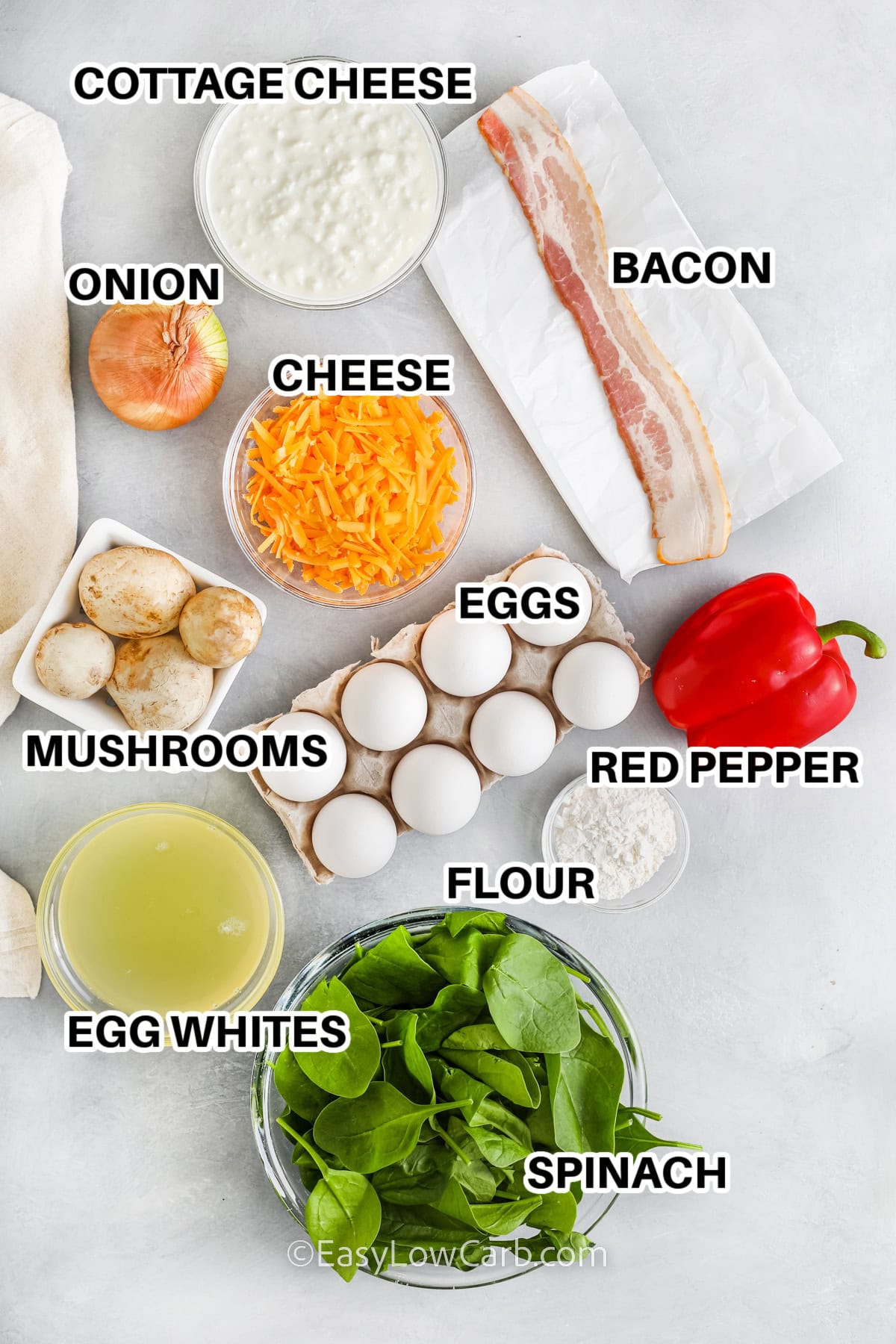 ingredients assembled to make best breakfast casserole, including cottage cheese, onion, mushrooms, eggs, spinach, shredded cheddar, and bacon