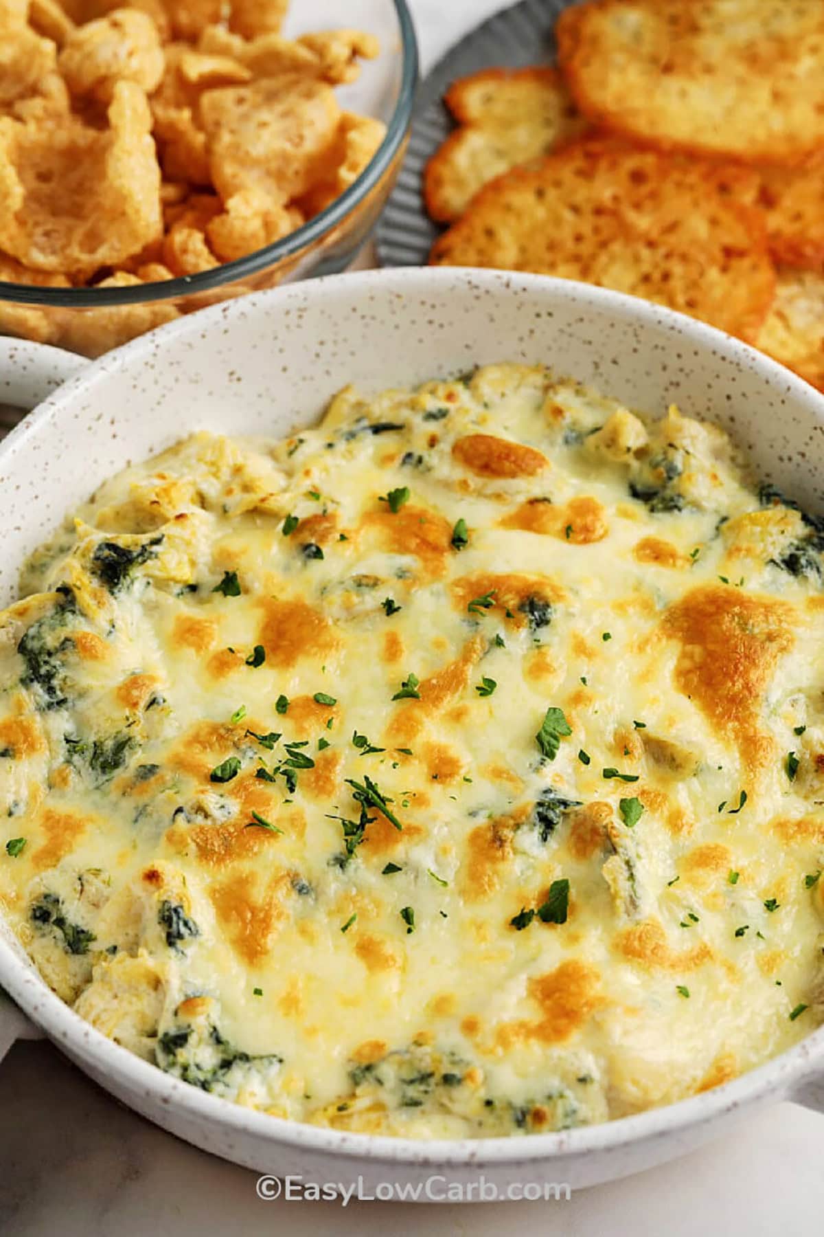 Hot spinach artichoke dip is the ultimate comfort food, and this easy recipe brings all the creamy, cheesy goodness you love in just minutes! With a perfect blend of spinach, artichokes, and gooey melted cheese, it’s the perfect appetizer for any party or cozy night in. Serve it with crispy chips, crunchy veggies, or warm bread for dipping. Everyone will be coming back for more! #easylowcarb plated Hot Spinach Artichoke Dip