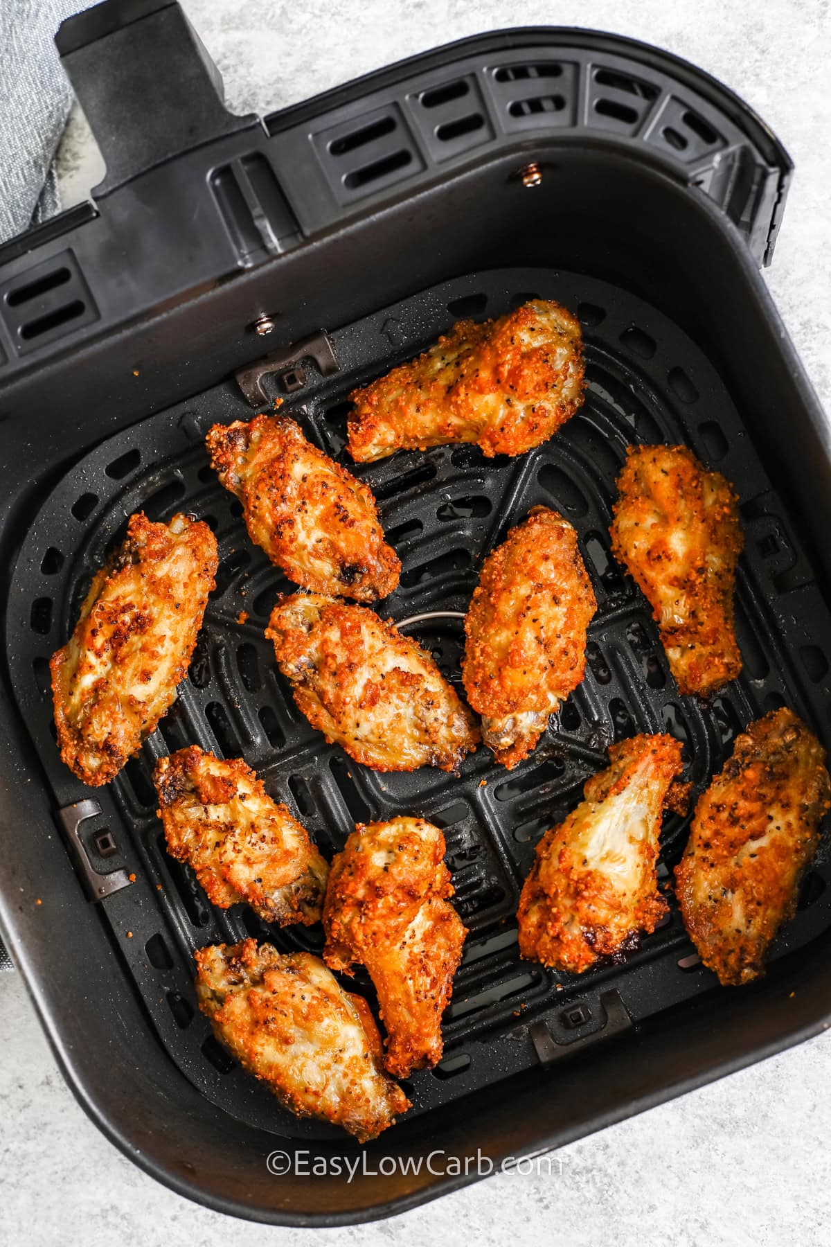 garlic parmesan chicken wings in an air fryer tray