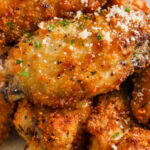garlic parmesan chicken wings on a plate with text