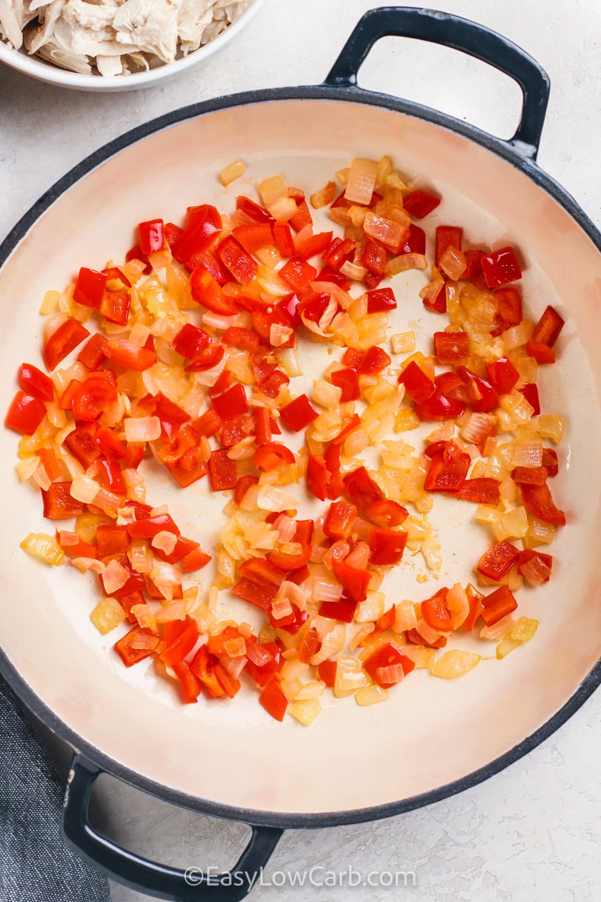 adding peppers and onions to pot to make Chicken Pasta Sauce