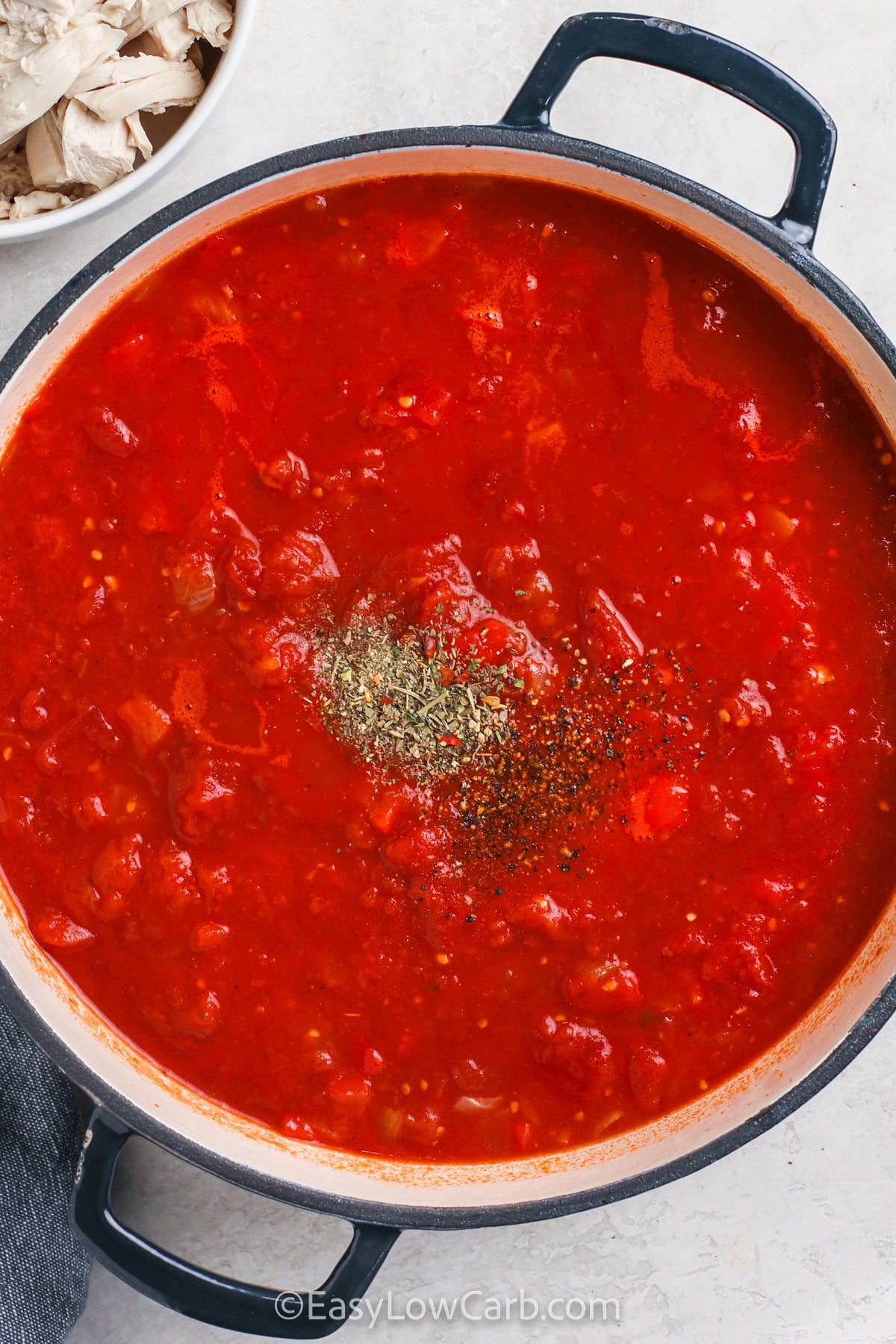 adding seasonings to pot to make Chicken Pasta Sauce