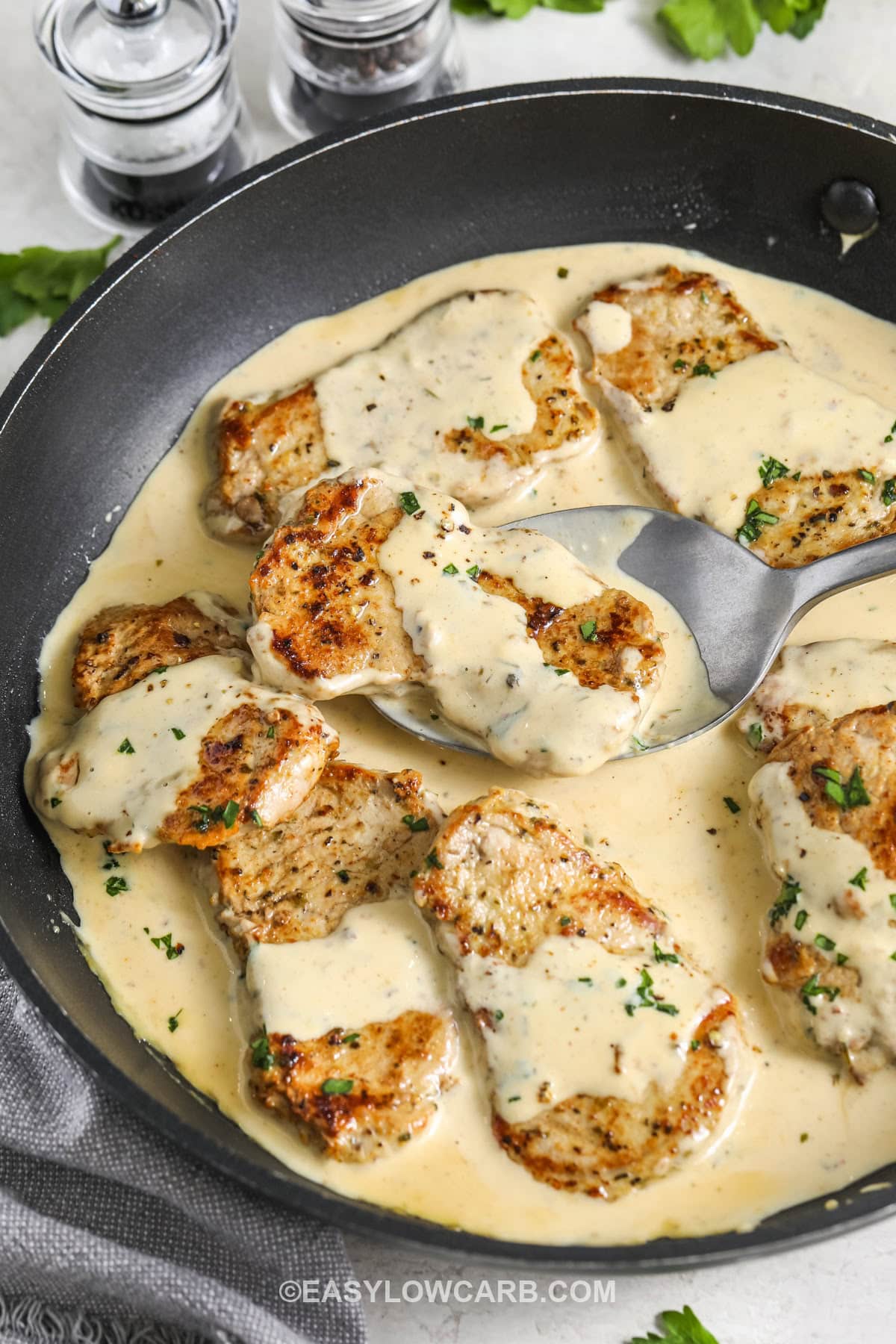 Creamy Dijon Pork Tenderloin Medallions in a pan with a spoon
