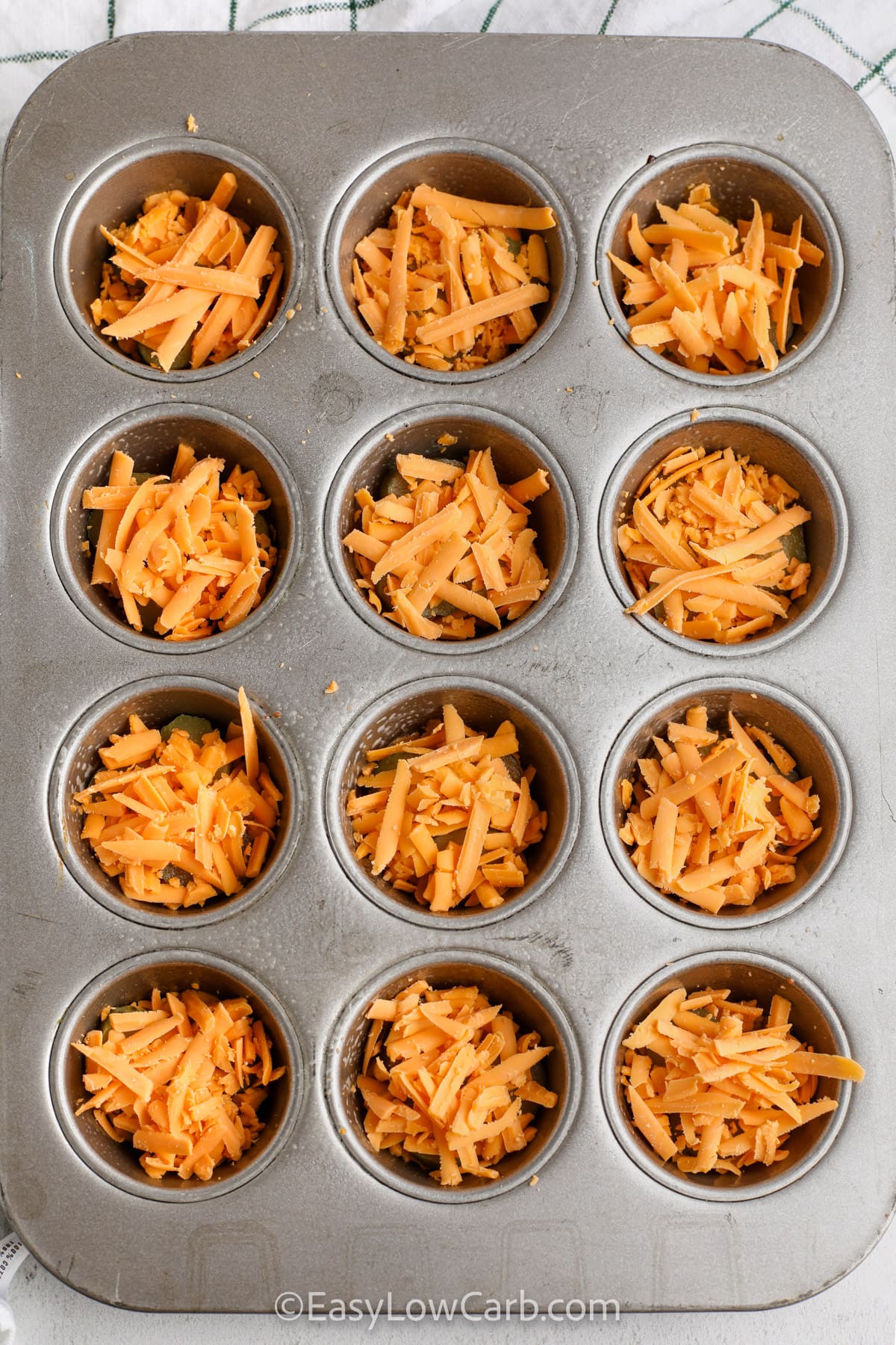 pickles and cheese layered in a muffin tin to make pickle chips